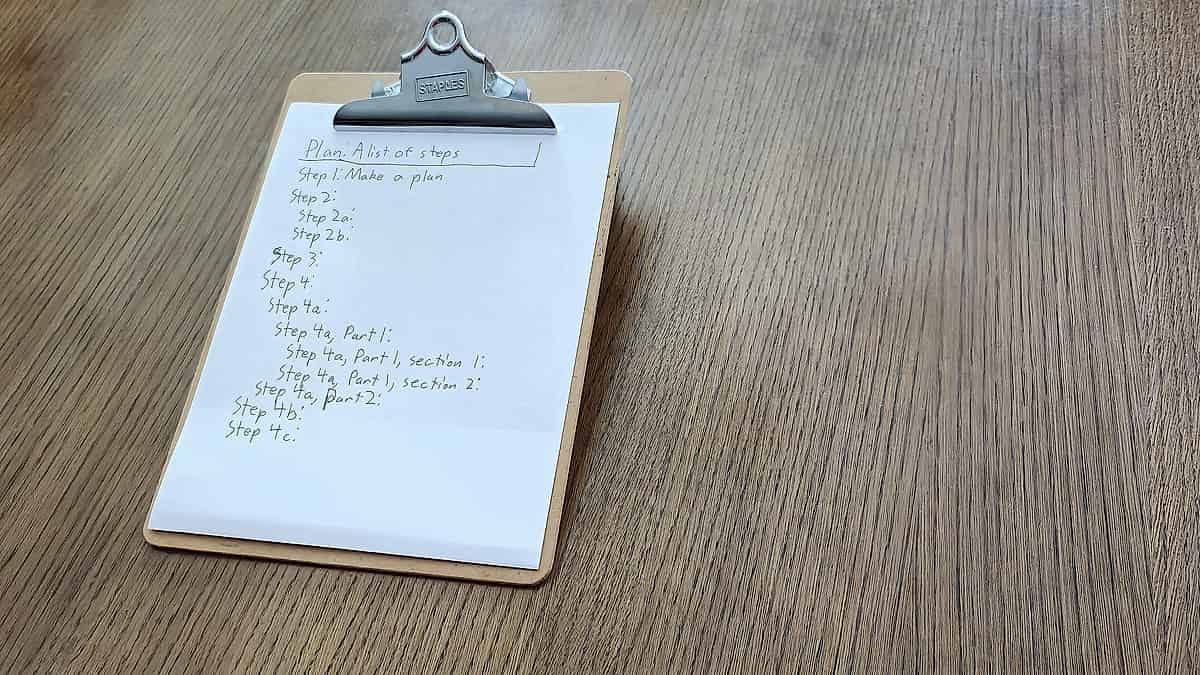 A clipboard and pen resting on a salon reception counter beside a card reader and a jar of clean combs